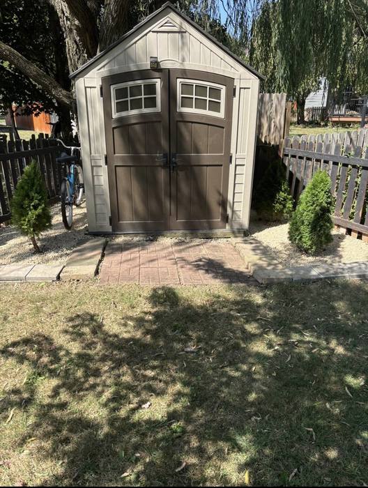 Landscaping around a backyard shed with mulch and ornamental plantings